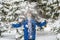 Young teenager boy throw snow up in front of him in the winter forest f