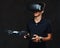 Young teenager dressed in a black t-shirt wears virtual reality glasses and controls the quadcopter using the control