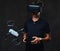 Young teenager dressed in a black t-shirt wears virtual reality glasses and controls the quadcopter using the control