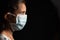 Young teenager girl with medical face mask in dark room at home quarantine due to covid 19 or coronavirus outbreak -