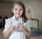 Young teenager girl showing thumbs up sign and holding a transparent glass. Child recommend drinking water. Good healthy habit