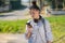 Young teenager girl waiting the school bus and using her smartphone