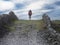 Young teenager girl walking up a hill on a rough small country road between stone fences. Aran Island, Ireland. Travel and tourism