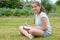 Young teenager sitting cross-legged and writing in the grass