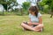 Young teenager sitting and writing cross-legged in the grass