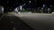 Young teenagers, woman and man riding scooters in the city park at night. Stock footage. Couple walking in the park