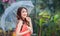 Young Thai lady standing with under umbrella