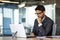 Young thinking businessman at workplace with laptop inside office, boss in glasses and business suit thinking about