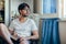 Young thoughtful man relax in chair at home with book