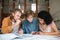 Young thoughtful people working in office. Two boys with blond hair and girl with dark curly hair sitting and studying