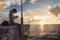 Young thoughtful women is sitting alone on a pier and writes sms