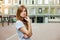 Young thoughtfull redhead woman walking around city