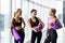 Young three Women taking break after workout session. Group of females in sportswear with exercise mat at gym