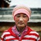 young tibetan buddhist pilgrim girl in front of the monastery wall