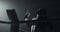 Young tired man drinking from the water bottle after training in the dark boxing ring with smoke. Silhouette. Boxing