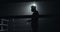 Young tired man drinking from the water bottle after training in the dark boxing ring with smoke. Silhouette. Boxing