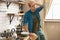 Young tired man standing in bright well-equipped modern kitchen looking exhausted after washing the dishes , bachelor life