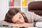 Young tired woman at office desk sleeping with eyes closed, sleep deprivation and stressful life concept