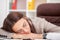 Young tired woman at office desk sleeping with eyes closed, sleep deprivation and stressful life concept