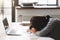 Young tired woman sleeping at office desk