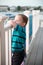 Young toddler boy on patio deck outside at sunset down at shore