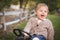 Young Toddler Laughing and Playing on Toy Tractor Outside