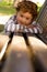 Young toddler lying on park bench