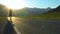 A young tourist with a backpack goes on the road in a mountainous area.