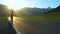 A young tourist with a backpack goes on the road in a mountainous area.