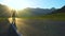 A young tourist with a backpack goes on the road in a mountainous area.