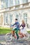 Young tourist couple, handsome man and pretty blond woman riding tandem bicycle along city street.