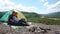 Young tourist couple have a sensual moment sitting in camping. Beautiful young man holds and kisses pretty girl