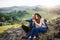 Young tourist couple travellers with binoculars hiking in nature, resting.