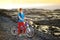 Young tourist cycling on lava field on Hawaii. Female hiker heading to lava viewing area at Kalapana town on her bike.