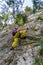 Young tourist female climbing towards an iron ladder on via ferrata `Echernwand`, a route in Hallstatt, Austria