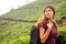 Young tourist girl with a backpack enjoying a good morning in tea plantations in India Munnar Kerala