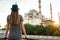 A young tourist girl with a beautiful figure looks from the hotel terrace to the world famous blue mosque Sultanahmet in