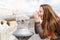 Young tourist girl watching city through telescope