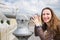 Young tourist girl watching city through telescope