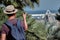 Young tourist in a hat with a backpack pointing to the bridge to Port of Barcelona