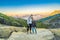 Young tourist man and woman stand at the edge of the crater of the Ijen volcano or Kawah Ijen on the Indonesian language