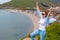 A young tourist woman climbed to the top of the mountain. Emotions of joy and happiness. Mountain and sea in the background. Close