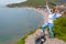 A young tourist woman climbed to the top of the mountain. Emotions of joy and happiness. Mountain and sea in the background. Copy