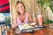 Young tourist woman eating fried rice and drinking fruit shake