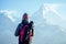 A young tourist woman with a hiking backpack and a knitted hat in the Himalaya mountains. trekking concept in the