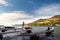 Young tourist woman standing on wooden berth with small boats near and making photo with her mobile of fantastic