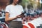 Young tourist woman in white t-shirt stands background of Bicycle Parking lot and uses smartphone, traveler girl using online app