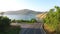 Young Tourists Couple Driving Motorbike at Beautiful Tropical Landscape Road with Sea View. HD Aerial Follow Shot.