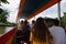 Young tourists in a long boat on the canals of Bangkok, Thailand