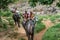 Young tourists are riding on elephants through the jungle